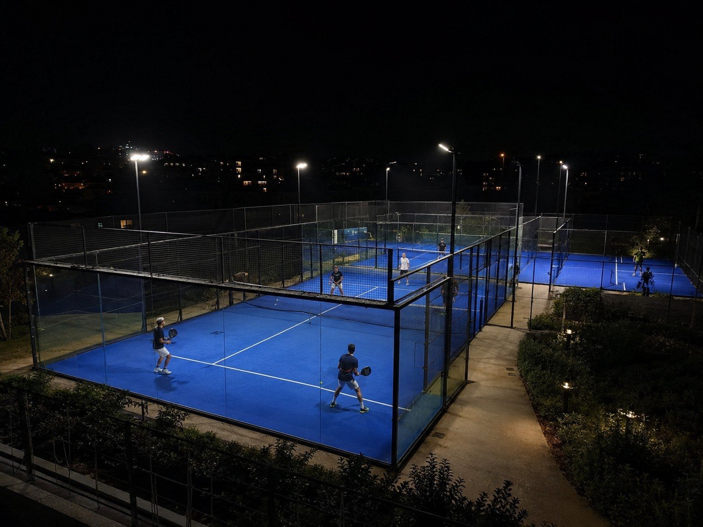 Illustrative padel and tennis court lighting at night